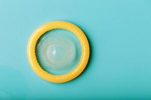 Opened condom on a blue background. Use of protection to reduce the likelihood of sexually transmitted diseases or pregnancy. photo