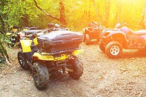 A group of ATVs in a forest covered in mud. Wheels and elements of all-terrain vehicles in mud and clay. Active leisure, sports and tourism photo
