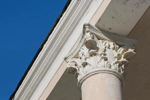 Element of an old ion column against a blue sky. Vintage element of building art photo