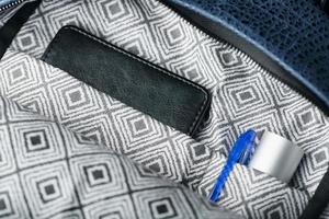 Close-up inside pockets, elements of a blue backpack made of genuine leather on a dark background, handmade. photo