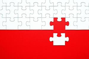 White puzzle pieces on a red background separated photo