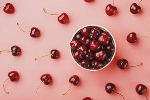 Cherry berry on a pink background in a white cup, top view. photo