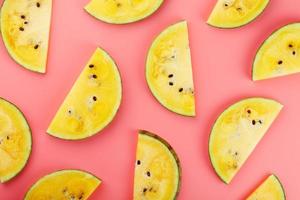 Slice of Yellow watermelon on a pink background. Bright summer background photo