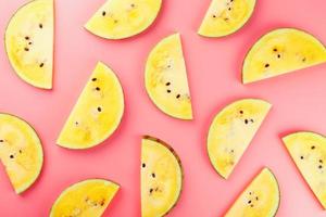 Juicy slices of yellow watermelon on a bright pink background. Conceptual colors of summer. Patterns top view as a background or substrate photo