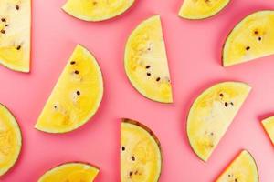 Juicy slices of yellow watermelon on a bright pink background. Conceptual colors of summer. Patterns top view as a background or substrate photo