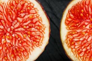 Figs are ripe. Closeup of sliced fig fruits in the form of a texture inscribed in a rectangle on a black texture background photo