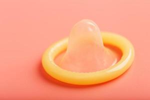 Condom on a pink background, close-up, top view. photo