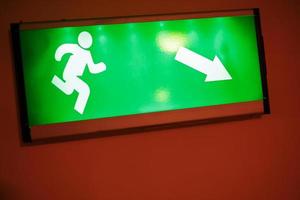 Green escape route sign on a flight of stairs. photo