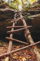 una antigua escalera que conduce a la cascada en el bosque de otoño. foto