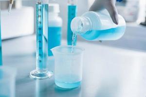 Analysis of the quality of liquids in a chemical laboratory, a device with equipment made of glass with a blue liquid photo