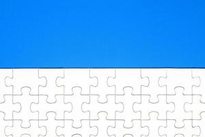 White puzzle pieces on blue background. Background for content photo