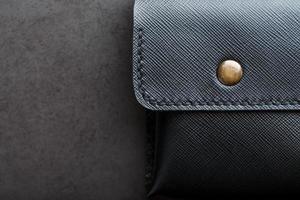 billetera negra hecha de cuero genuino sobre un fondo oscuro. artículos de cuero hechos a mano foto