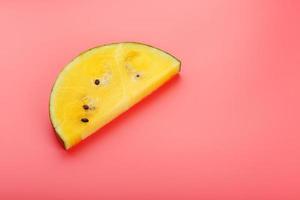 Slice of Yellow watermelon on a pink background. Bright summer background photo