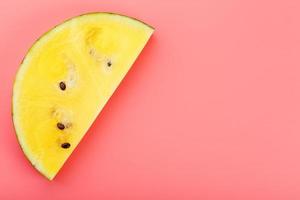 Slice of Yellow watermelon on a pink background. Bright summer background photo