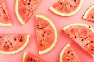 Slices of red watermelon on a pink background in the form. Minimal food concept idea. Flat lay, top view. photo