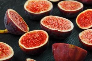 Ripe Figs. Creative diagram of chopped figs on a black textural background in the form of a texture inscribed in a rectangle photo