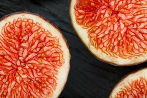 Ripe Figs. Creative diagram of chopped figs on a black textural background in the form of a texture inscribed in a rectangle photo