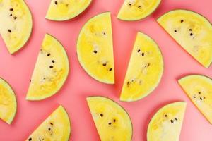 Juicy slices of yellow watermelon on a bright pink background. Conceptual colors of summer. Patterns top view as a background or substrate photo