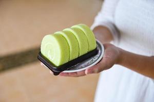 cake roll on plate - woman served green cake roll pandan with cream photo