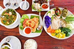 Vista superior de comida tailandesa comida asiática servida en mesa de madera con menú de placa en Tailandia foto