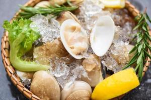 mariscos mariscos con hielo congelado en la cesta almeja de concha fresca con ingredientes de hierbas para ensalada , concha de venus esmaltada , almejas de agua salada
