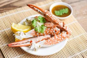 Boiled crab food on white plate and seafood sauce on the table - crab claws shellfish photo