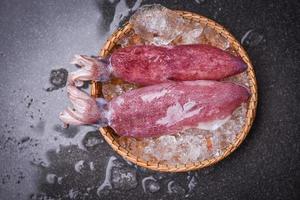 calamares crudos en hielo congelado en el mercado de mariscos de la cesta - calamares frescos, pulpo o sepia para el restaurante de ensaladas de comida cocinada foto