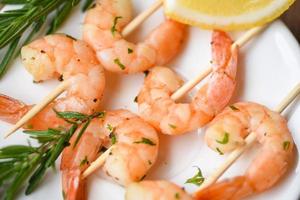 Salad grilled shrimp skewers delicious seasoning spices on white plate appetizing cooked shrimps baked prawns , Seafood shelfish with rosemary and lemon photo