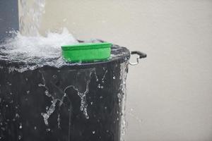 Bucket with water splashes rain water harvesting in the bucket of water after rain photo