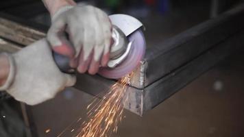 Grinding of corners of steel structure. Metal treatment. Disk rotates and sparks fly. Work in workshop. video