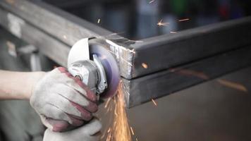 Grinding of corners of steel structure. Metal treatment. Disk rotates and sparks fly. Work in workshop. video