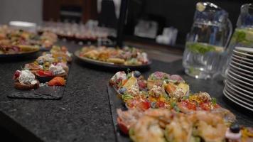 Set of beautiful canapes on black stone plates. Buffet table. Catering in cinematic video. video