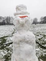 muñeco de nieve en un parque de invierno frío foto