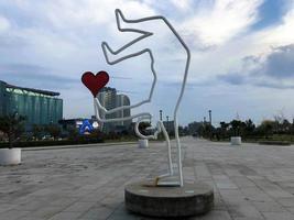 Abstract statues, small architectural forms with a man holding a heart on a skateboard on Batumi Primorsky Boulevard or Batumi Beach. Georgia, Batumi, April 17, 2019 photo
