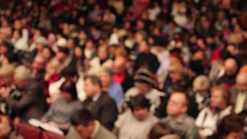 la foule est assise et écoute lors d'un spectacle video