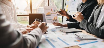 Business documents on office table with smart phone and calculator digital tablet and graph business with social network diagram and two colleagues discussing data working in the office photo