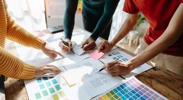UX developer and ui designer brainstorming about mobile app interface wireframe design with customer breif and color code at office. photo