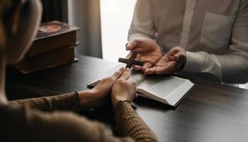 mano de mujer con cruz. concepto de esperanza, fe, cristianismo, religión, iglesia y oración a dios. en la mesa foto