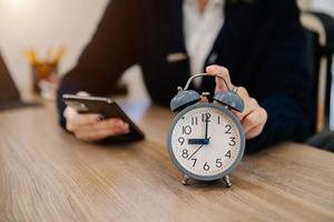 Alarm clock on the desk. Business working in modern office building or home at night using laptop. photo