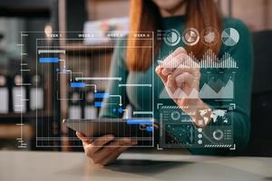 Businessman hand Project manager working and update tasks and Gantt chart scheduling virtual diagram.with smart phone, tablet and laptop in office. photo