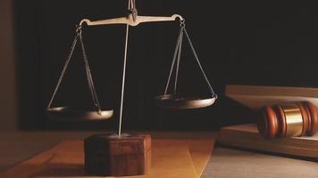 Justice and law concept.Male judge in a courtroom with the gavel, working with, computer and docking keyboard, eyeglasses, on table in morning light video