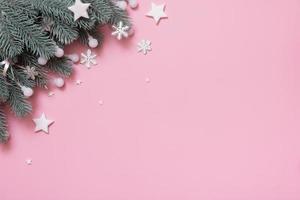 Pine trees branches with Cristmas New Year decoration top view, flat lay on pink background with copy space. Blank greeting card photo