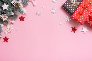 Pine trees branches with Cristmas New Year decoration top view, flat lay on pink background with copy space. Blank greeting card photo