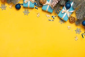 Christmas background with pine tree, gifts and festive decorations in Ukraine colors top view. Christmas flat lay. Copy space