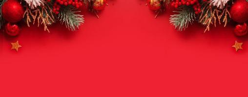 Banner with Christmas decoration and pine tree on red background with copy space. New Year greeting banner. photo