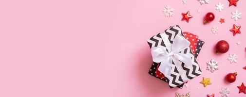 Christmas presents flat lay on a pink background. Top view xmas gifts with decorations photo