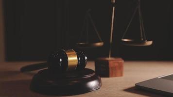 Justice and law concept.Male judge in a courtroom with the gavel, working with, computer and docking keyboard, eyeglasses, on table in morning light video