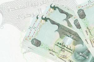 10 UAE dirhams bills lies in stack on background of big semi-transparent banknote. Abstract presentation of national currency photo