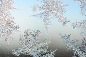 Snowflakes frost rime macro on window glass pane photo