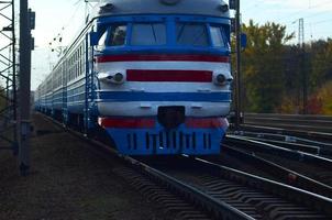 Old soviet electric train with outdated design moving by rail photo